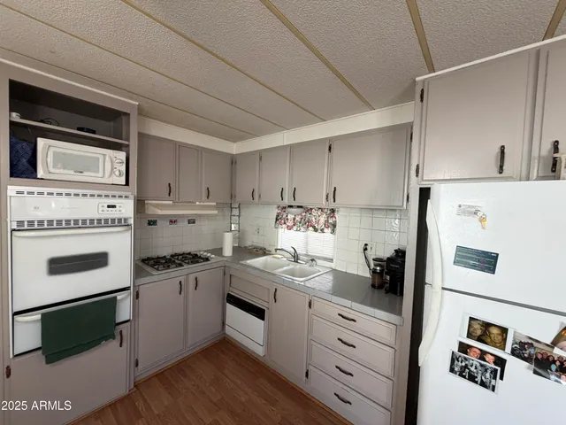 a kitchen with white cabinets and white appliances