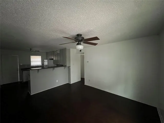 a view of empty room with wooden floor and window