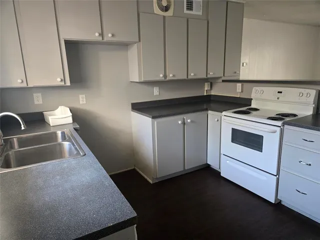 a kitchen with a sink stove and cabinets