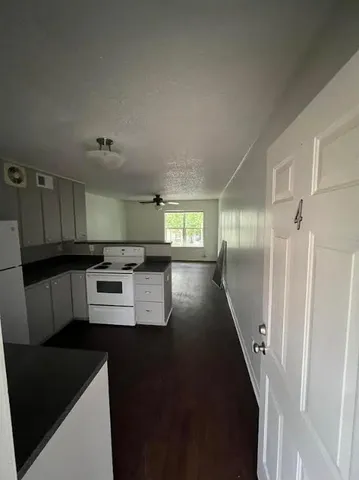a kitchen with kitchen island wooden cabinets and refrigerator
