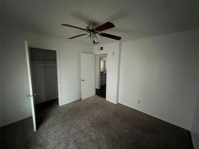 a view of empty room with ceiling fan