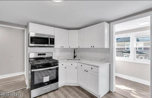 a kitchen with granite countertop a sink and a stove top oven