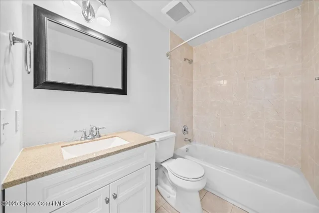 a bathroom with a granite countertop sink a toilet and a bathtub
