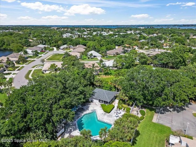 an aerial view of residential houses with outdoor space and trees
