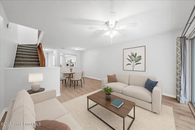 a living room with furniture and a ceiling fan