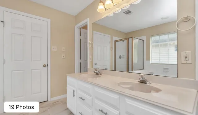 a bathroom with a double vanity sink and a mirror