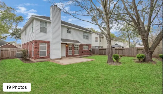 a view of a house with a yard and a tree