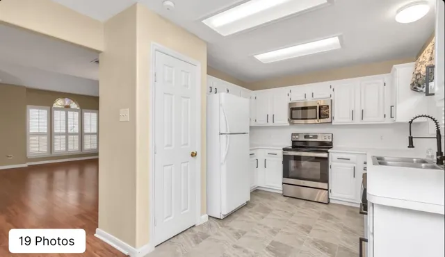 a kitchen with stainless steel appliances granite countertop a refrigerator sink and stove