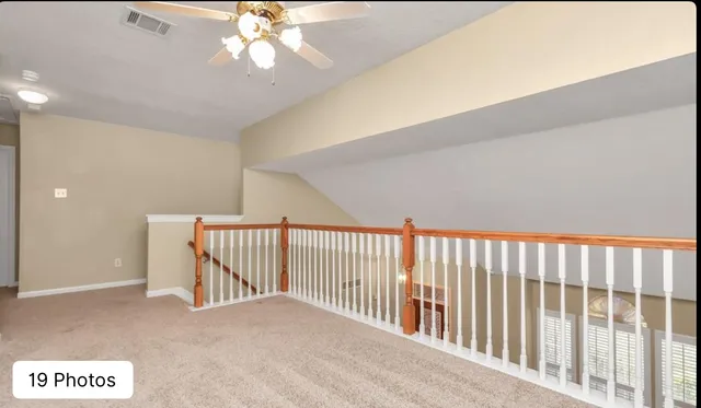 a view of a hallway with a ceiling fan