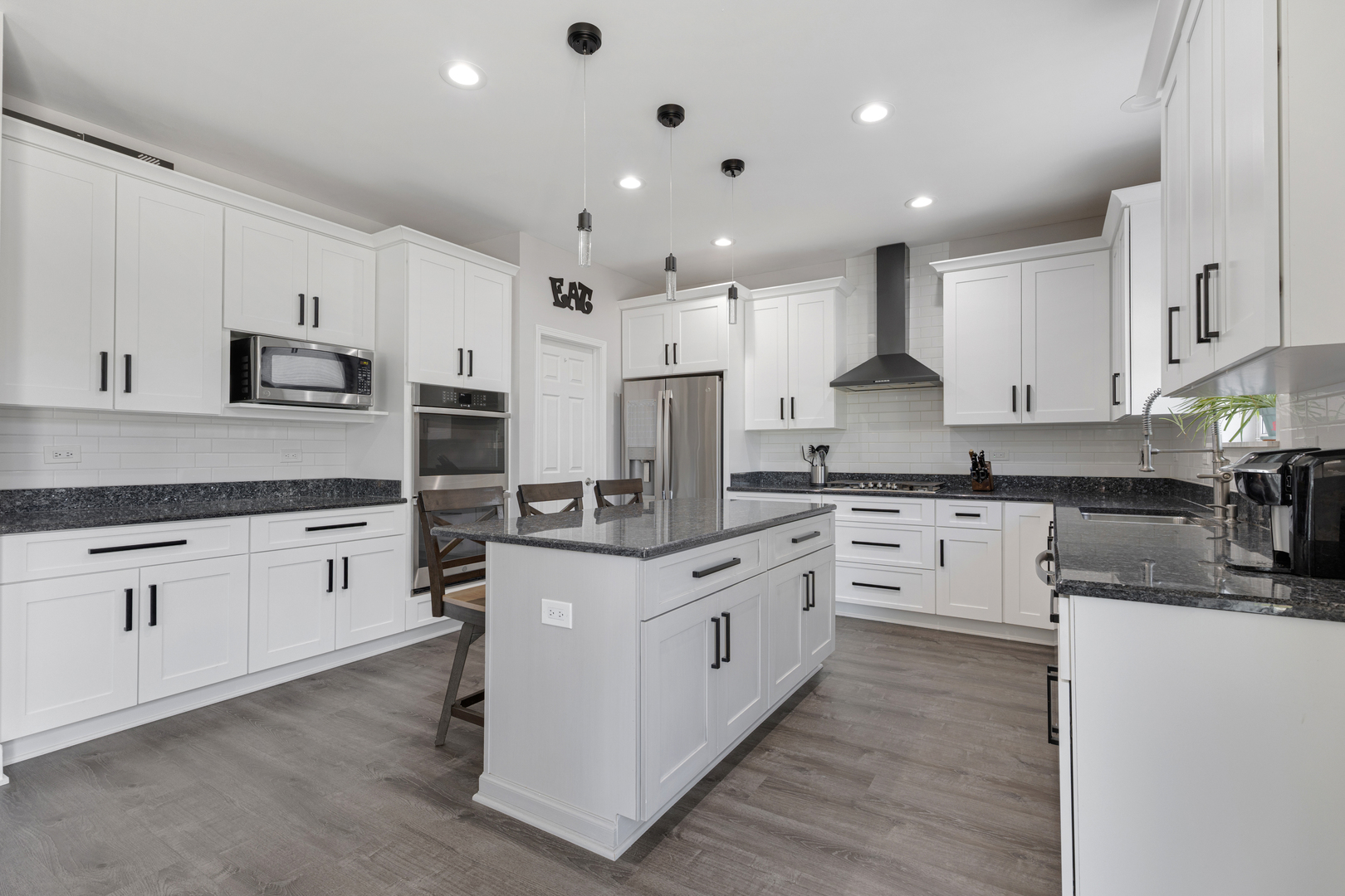 2751 Cedar Creek Cutoff Road Wauconda, IL 60084 - Photo 11 of 34 a kitchen with stainless steel appliances granite countertop a stove top oven a sink a refrigerator and white cabinets with wooden floor