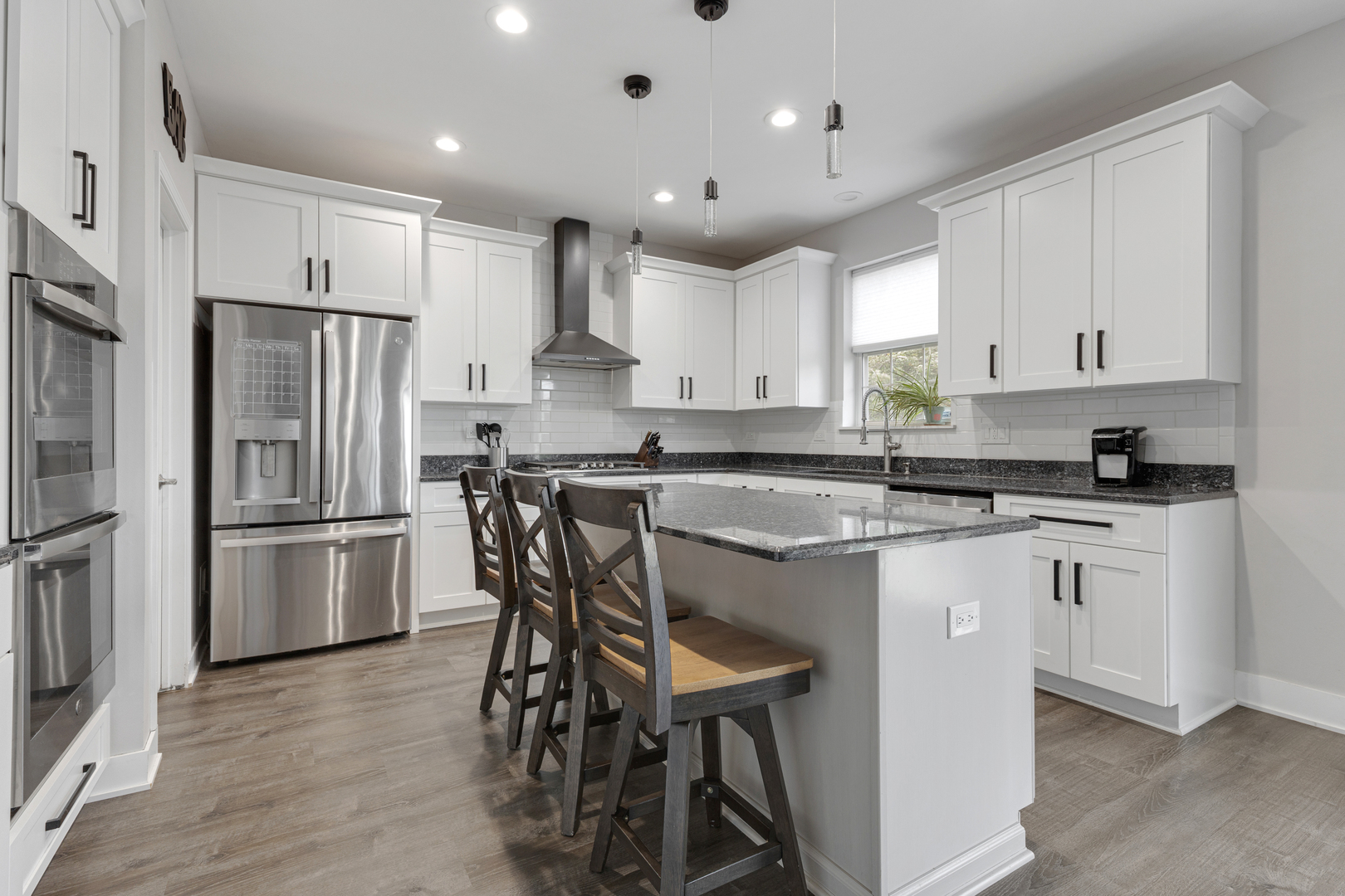 2751 Cedar Creek Cutoff Road Wauconda, IL 60084 - Photo 9 of 34 a kitchen with stainless steel appliances granite countertop a stove a sink a refrigerator and white cabinets with wooden floor