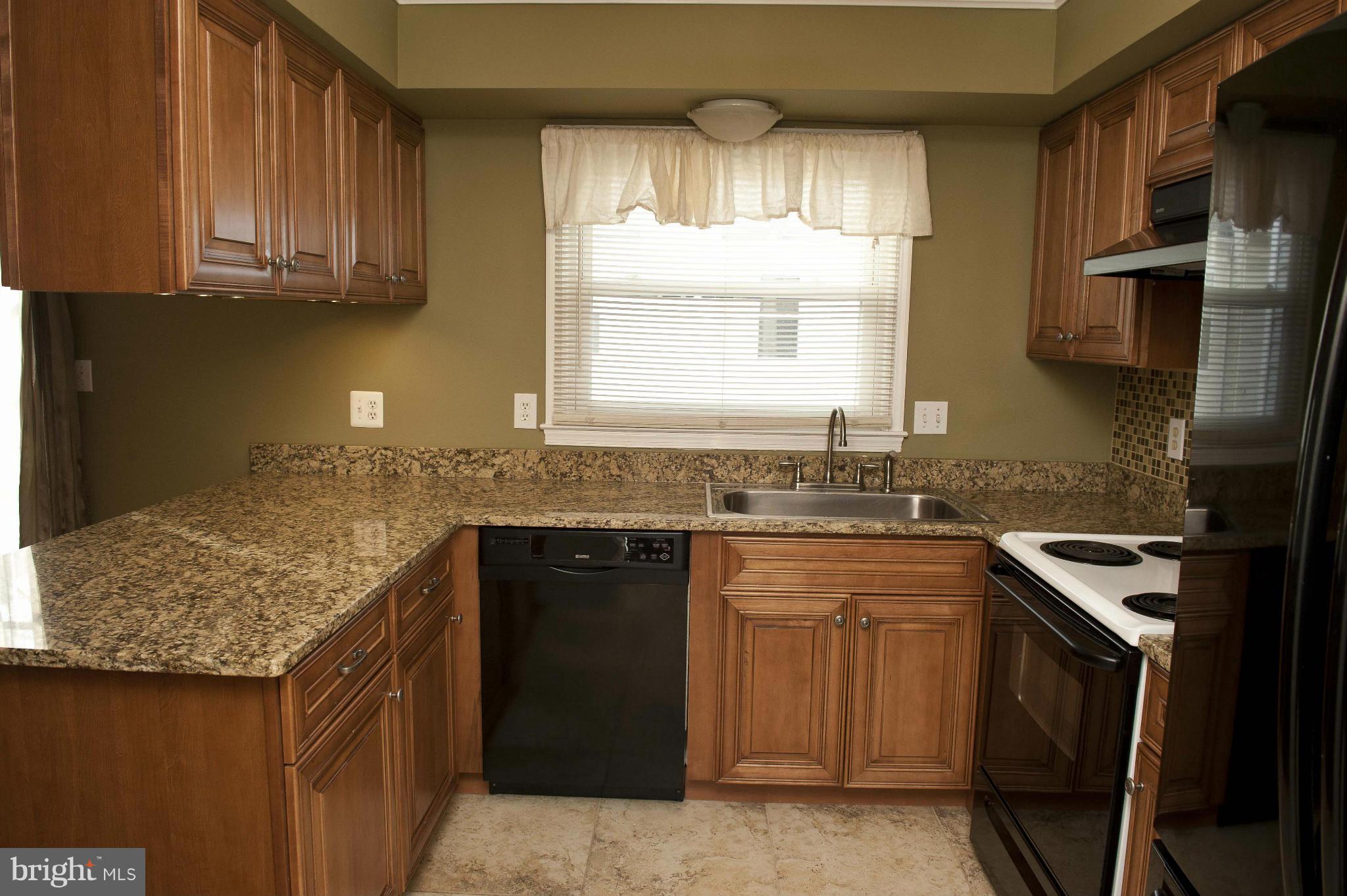 13232 Country Ridge Drive Germantown, MD 20874 - Photo 3 of 30 a kitchen with granite countertop a sink stove and cabinets