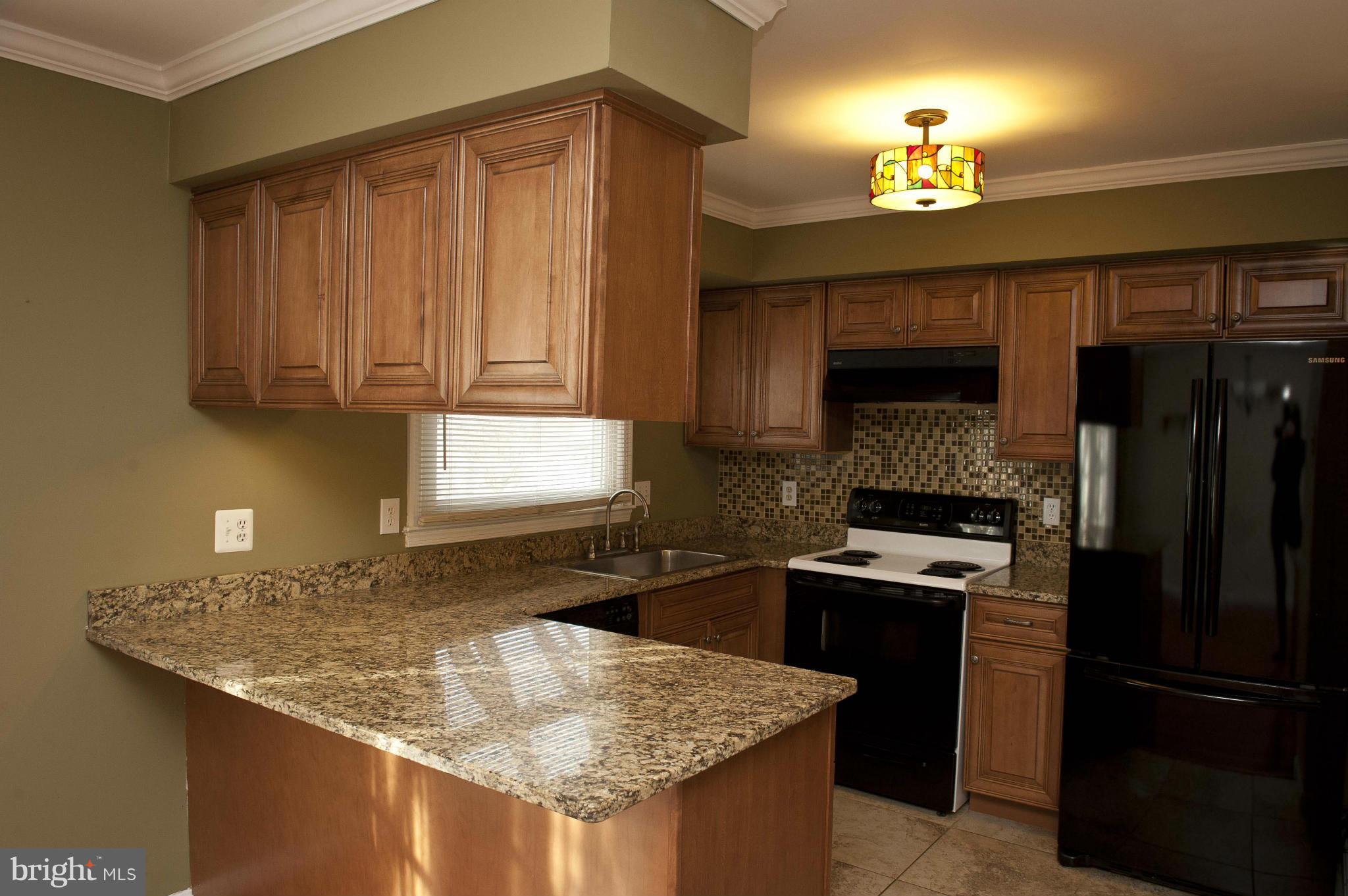 13232 Country Ridge Drive Germantown, MD 20874 - Photo 4 of 30 a kitchen with granite countertop stainless steel appliances and wooden cabinets