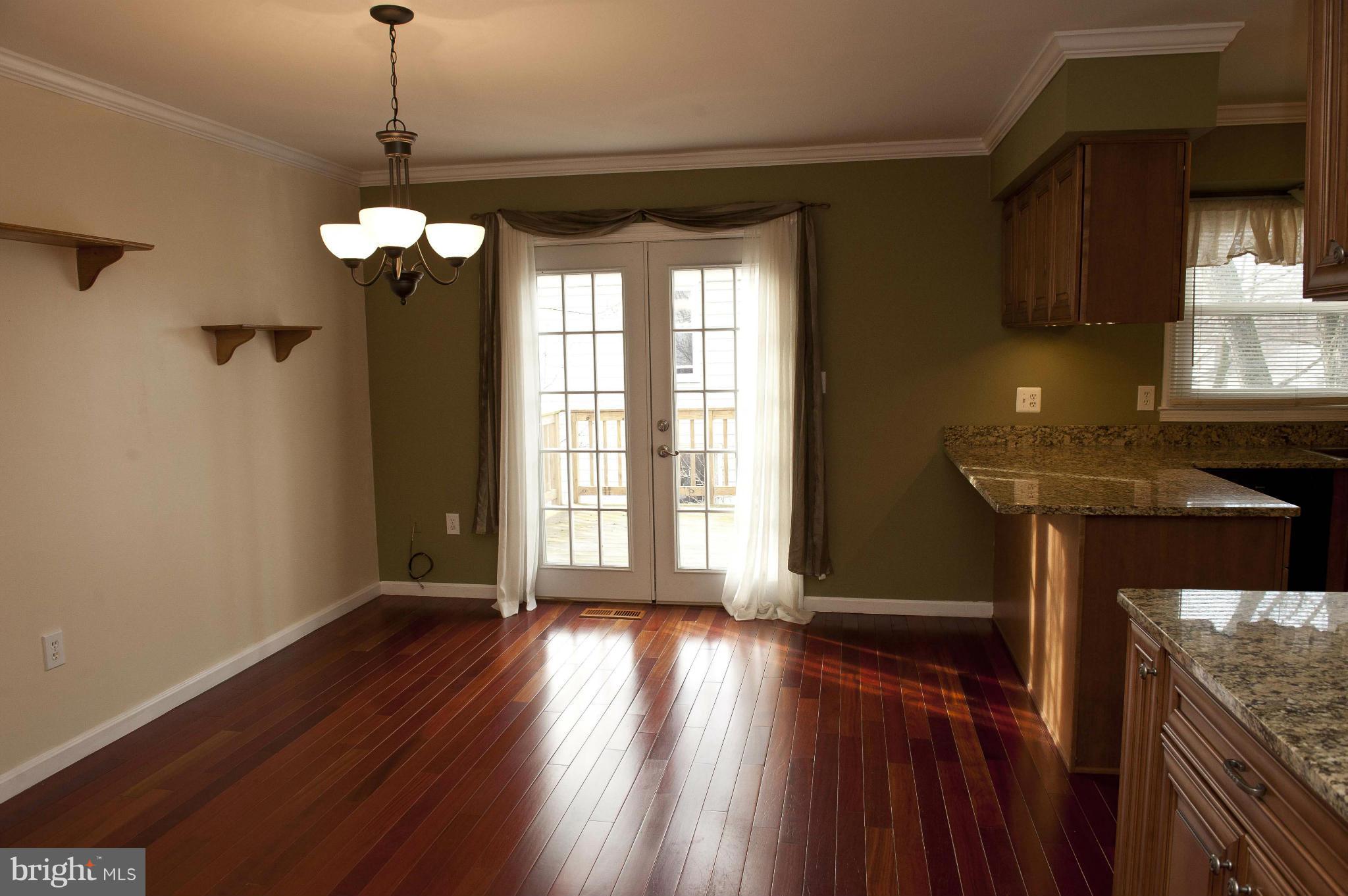 13232 Country Ridge Drive Germantown, MD 20874 - Photo 6 of 30 a view of a room with wooden floor a ceiling fan and a kitchen