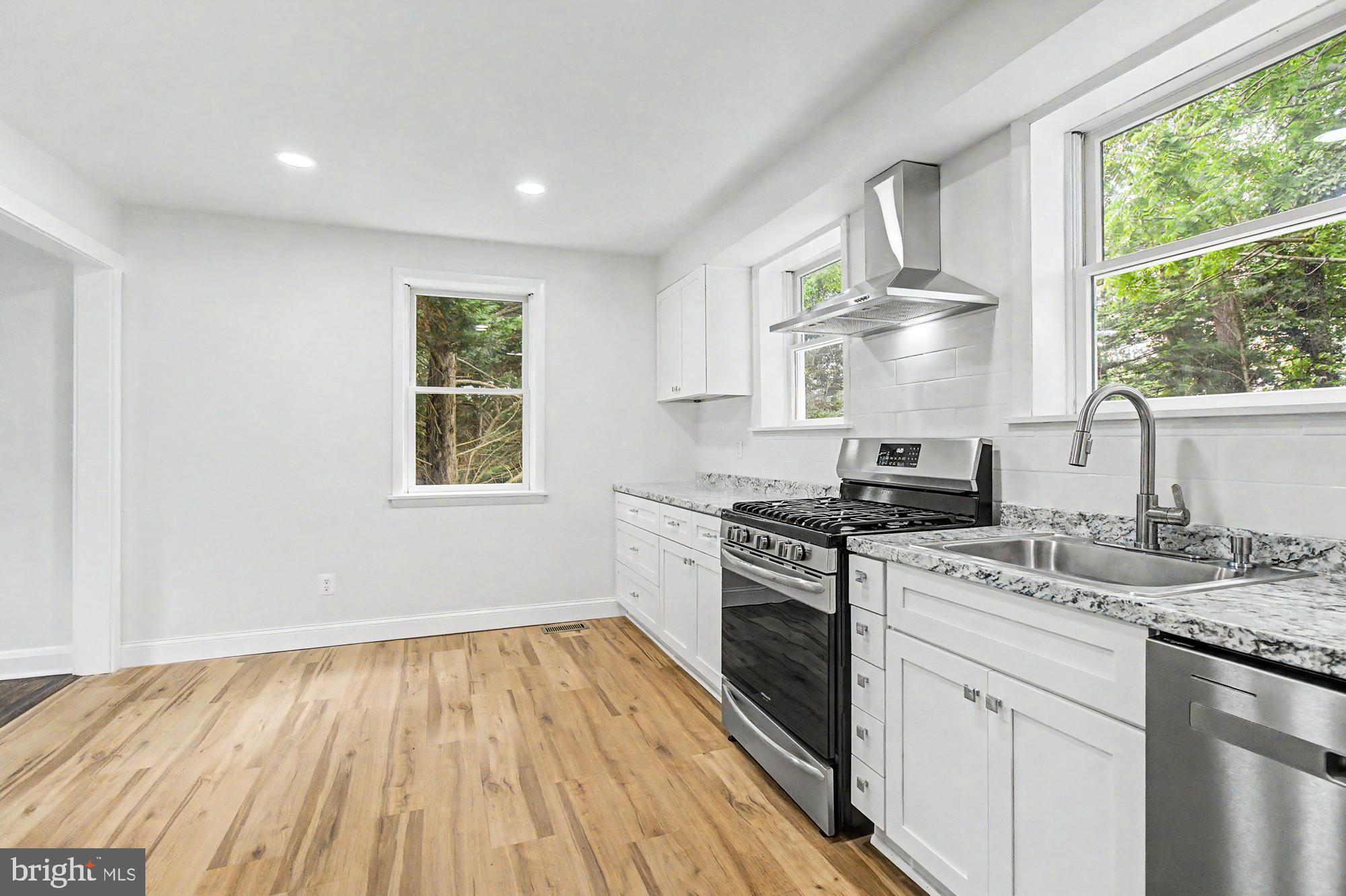 604 Prospect Mill Road Bel Air, MD 21015 - Photo 13 of 36 a kitchen with a stove wooden floors and a window