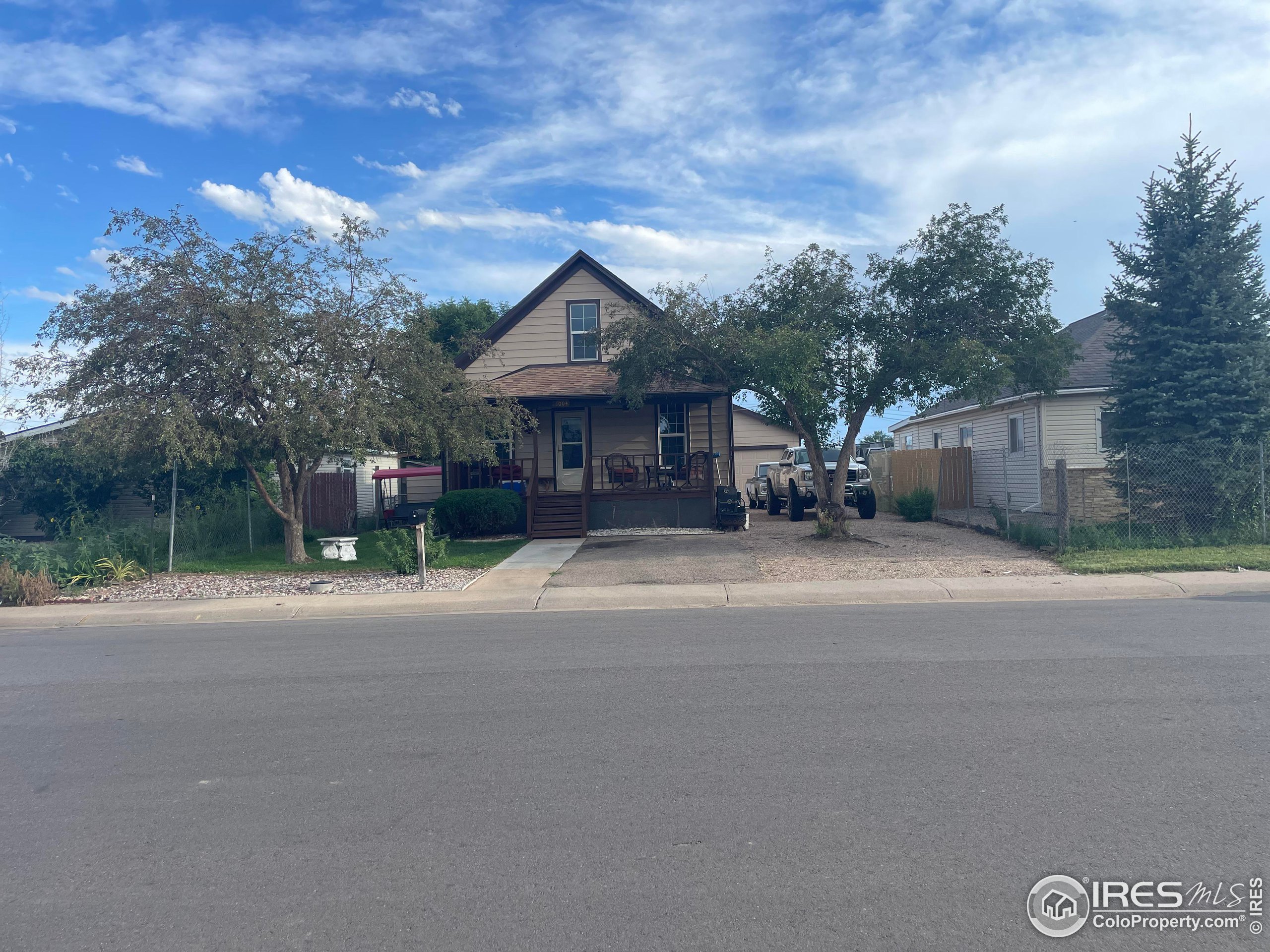 1004 1st Street Greeley, CO 80631 - Photo 2 of 27 a front view of a house with a garden and trees