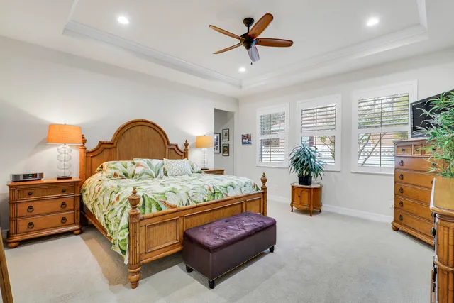 a bedroom with a bed and a flat tv screen on dresser