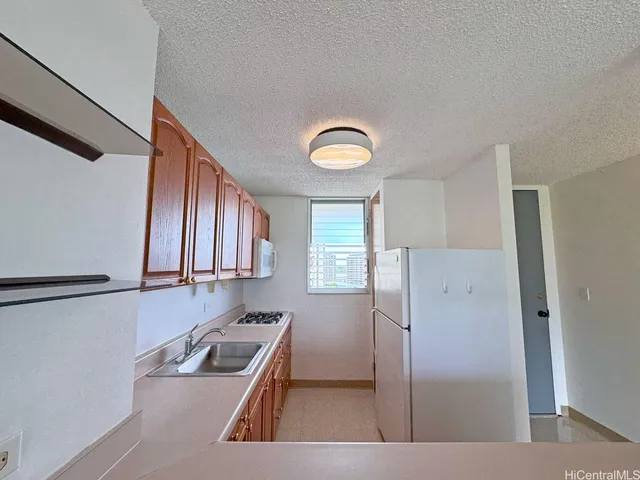 a kitchen with a refrigerator sink and cabinets