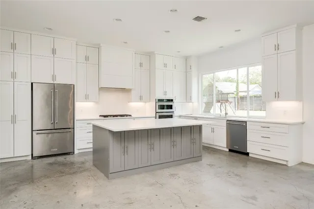 a kitchen with white cabinets and refrigerator
