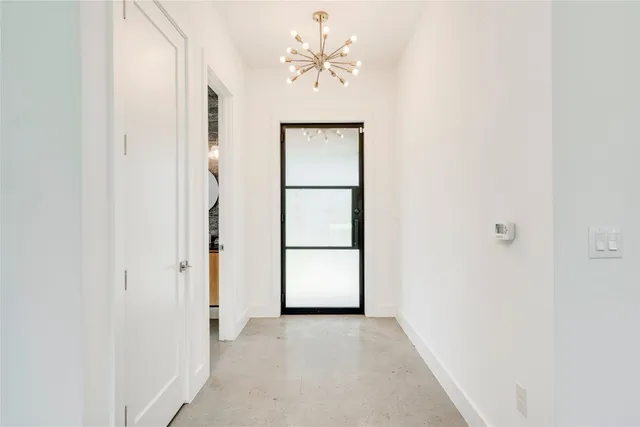 an empty room with windows and a ceiling fan