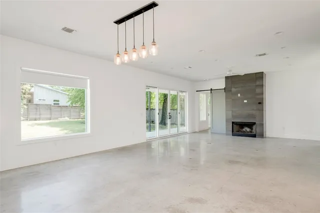 a view of an empty room with a fireplace and a window