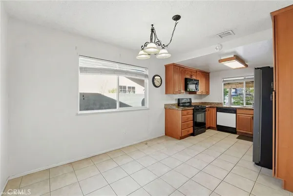 a kitchen with stainless steel appliances granite countertop a stove a sink dishwasher and a refrigerator
