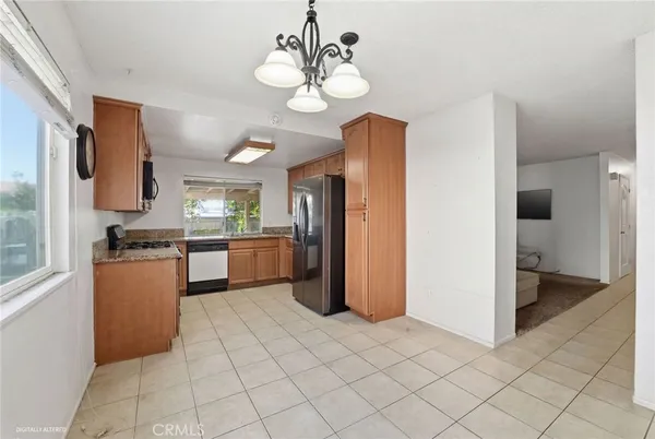 a kitchen view with stainless steel appliances a refrigerator and a stove top oven