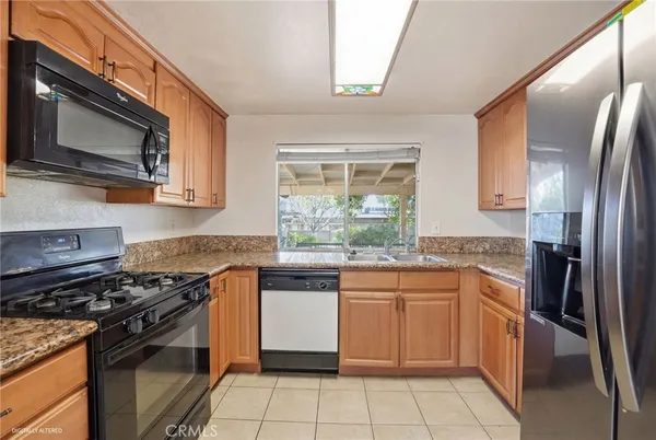a kitchen with stainless steel appliances granite countertop a stove a sink dishwasher and a refrigerator