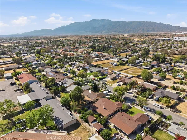 an aerial view of residential house with parking and trees