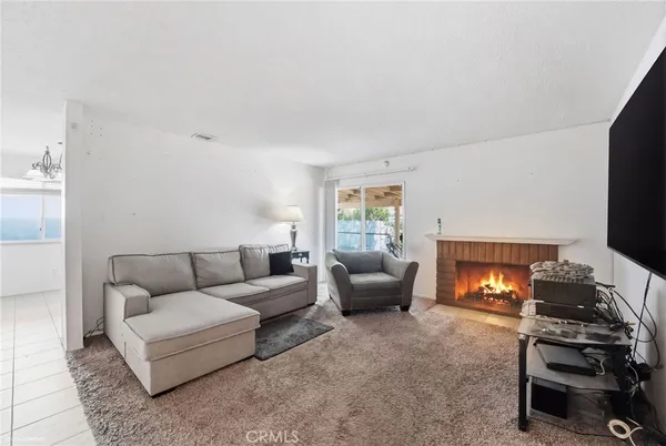 a living room with furniture a flat screen tv and a window
