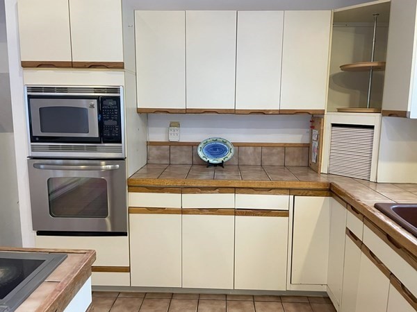 64 James Road Hanover, MA 02339 - Photo 10 of 40 a kitchen with stainless steel appliances granite countertop a stove a microwave and a white cabinets