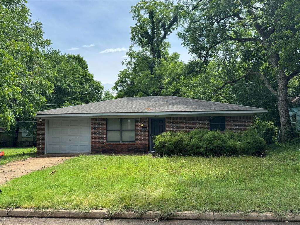 4515 Southeast Loop 286 Paris, TX 75460 - Photo 10 of 37 a view of a house with a yard and a garden