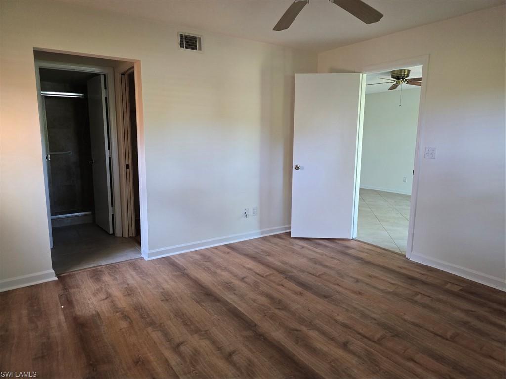 5737 Whitaker Road, Unit C104 Naples, FL 34112 - Photo 24 of 35 Wood-finish flooring and entrance to bathroom and walk in closet