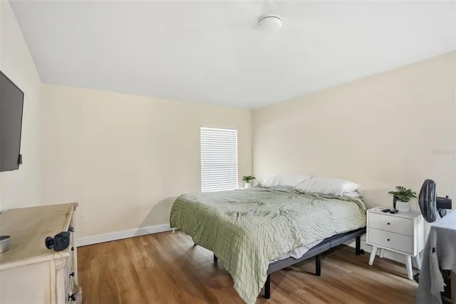 a bedroom with a bed and wooden floor