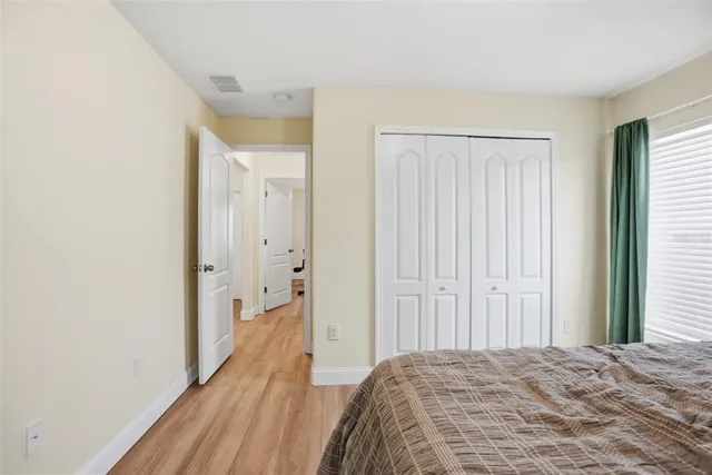 a view of a bedroom with wooden floor and bathroom