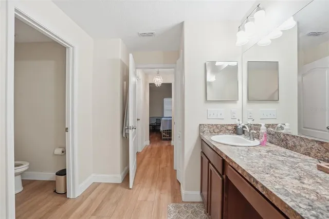 a en suite bathroom with a granite countertop sink and a mirror