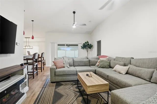 a living room with furniture a flat screen tv and kitchen view