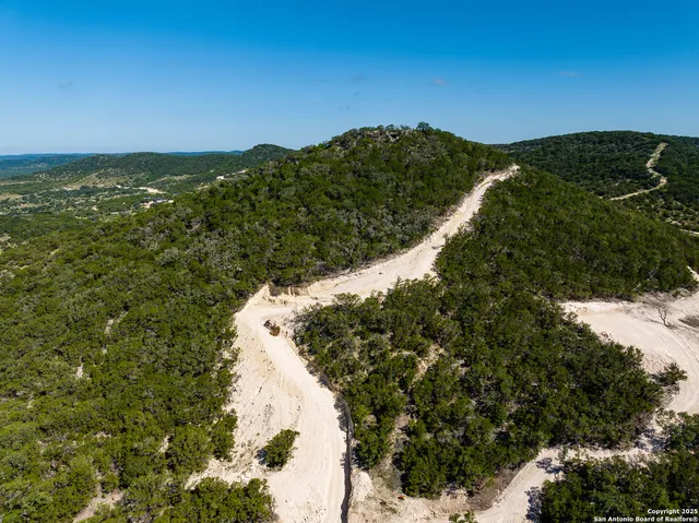 a view of a dry yard with wooden fence