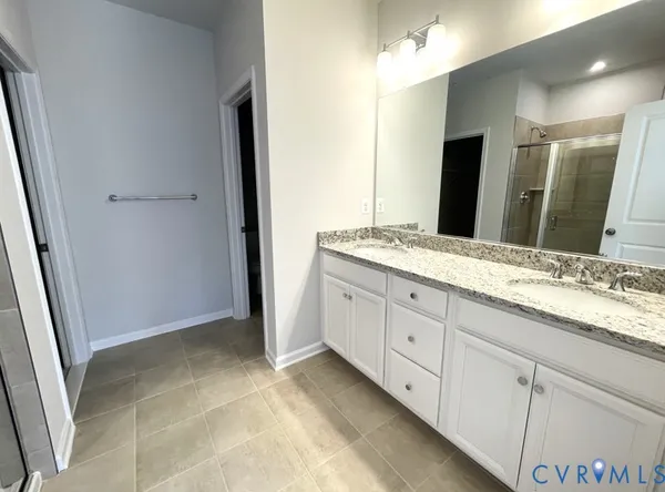 a spacious bathroom with a granite countertop sink a mirror and a