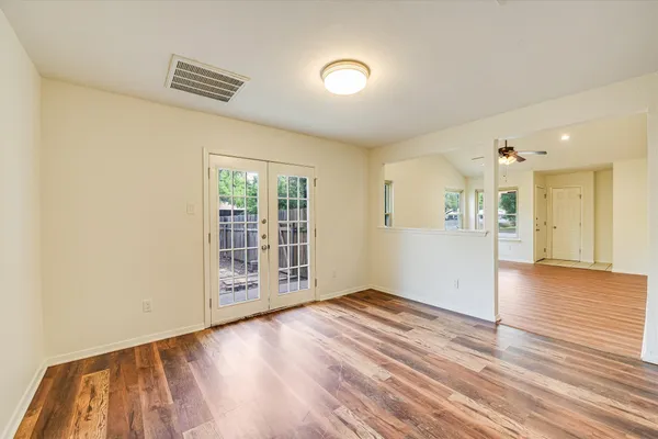 a view of a room with wooden floor and a window