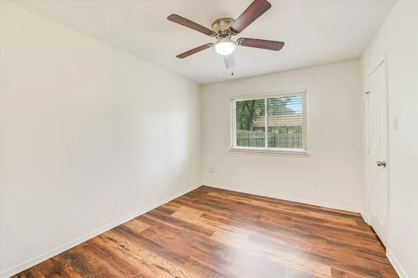 an empty room with a window and a ceiling fan