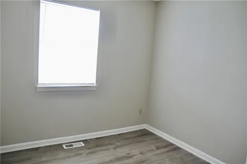 a view of a small space with wooden floor and a window