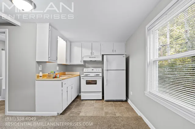 a kitchen with stainless steel appliances a white cabinets and a window