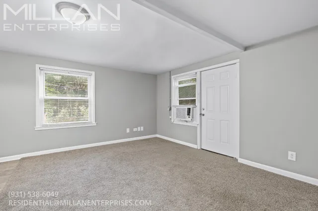 an empty room with windows and closet