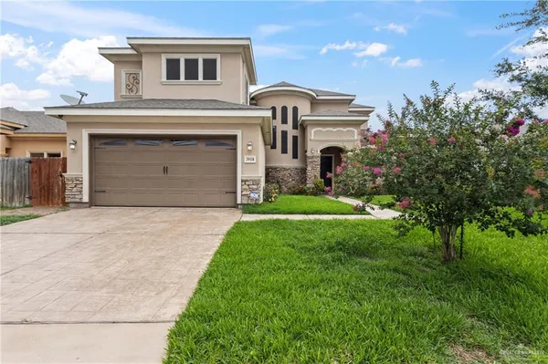 a front view of a house with a garden and garage
