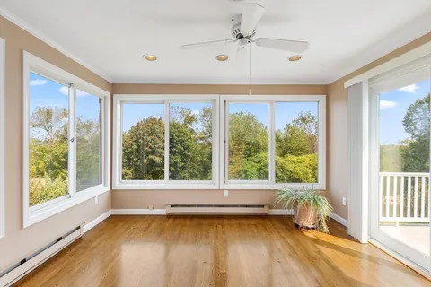 a view of a room with a large window and wooden floor