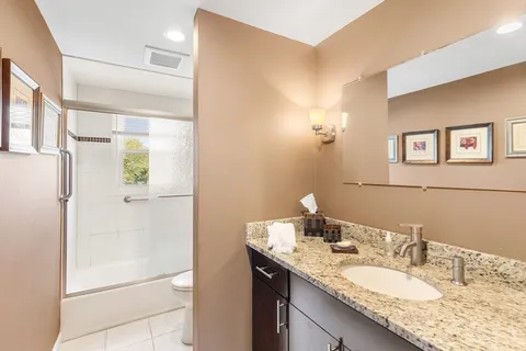 a bathroom with a granite countertop sink and a mirror