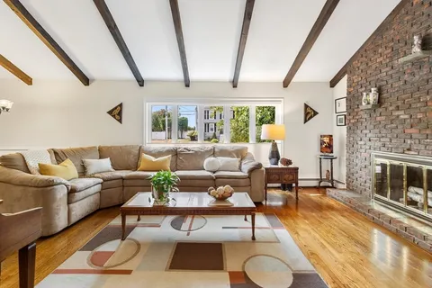 a living room with furniture a fireplace and next to a window