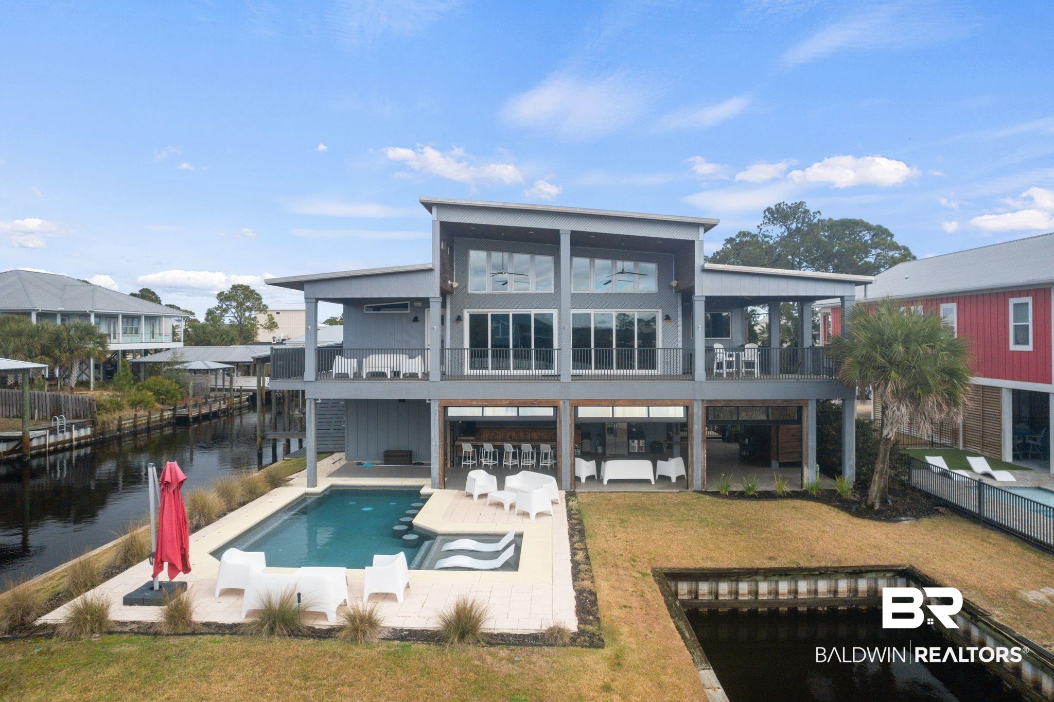 3840 Cotton Way Orange Beach, AL 36561 - Photo 65 of 75 Rear view of house featuring a yard, a balcony, exterior bar, a patio area, and a water view