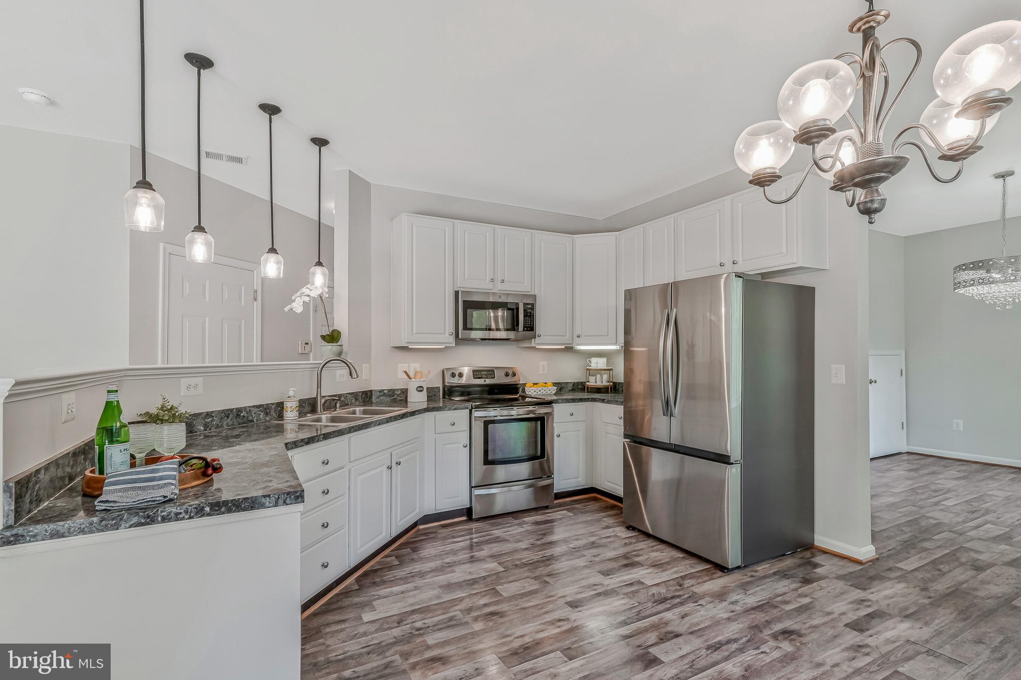 11587 Wollaston Circle Swan Point, MD 20645 - Photo 11 of 55 a kitchen with stainless steel appliances granite countertop a sink a refrigerator a stove a microwave and island